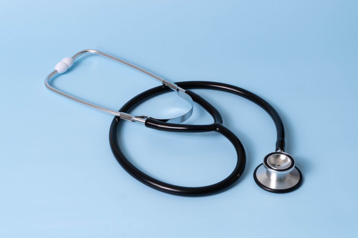 Close-up of a classic stethoscope on a blue background, symbolizing healthcare and medical profession.
