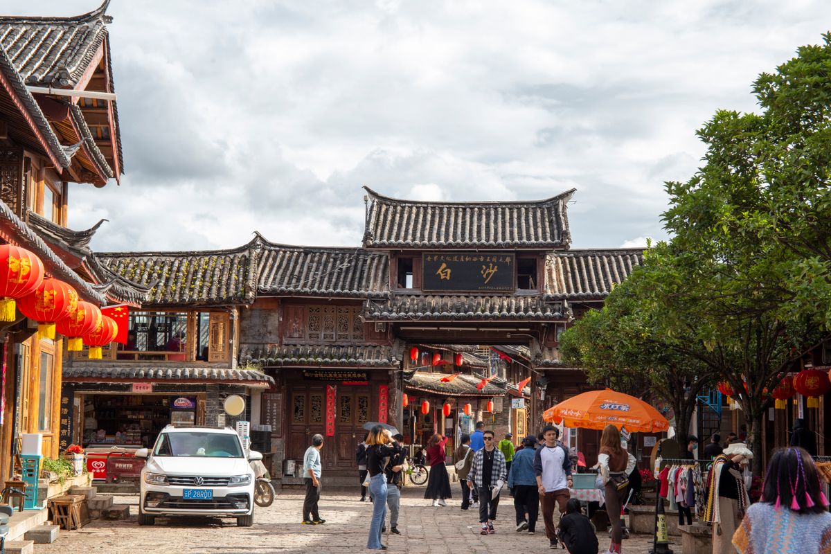 Vibrant scene in Lijiang's Old Town showcasing traditional Chinese architecture and bustling pedestrian activity.