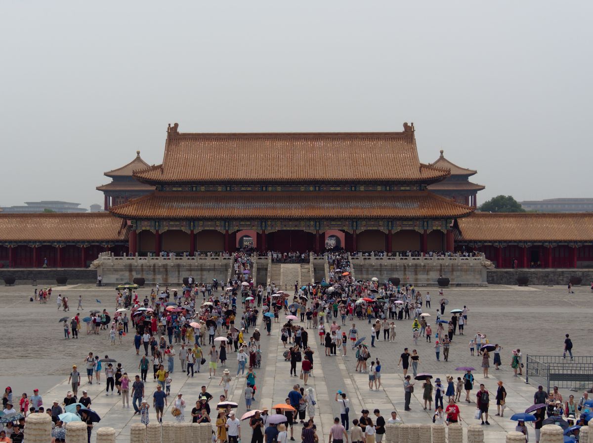 Crowds admire the historic architecture of the Forbidden City, Beijing, a dynamic travel destination.